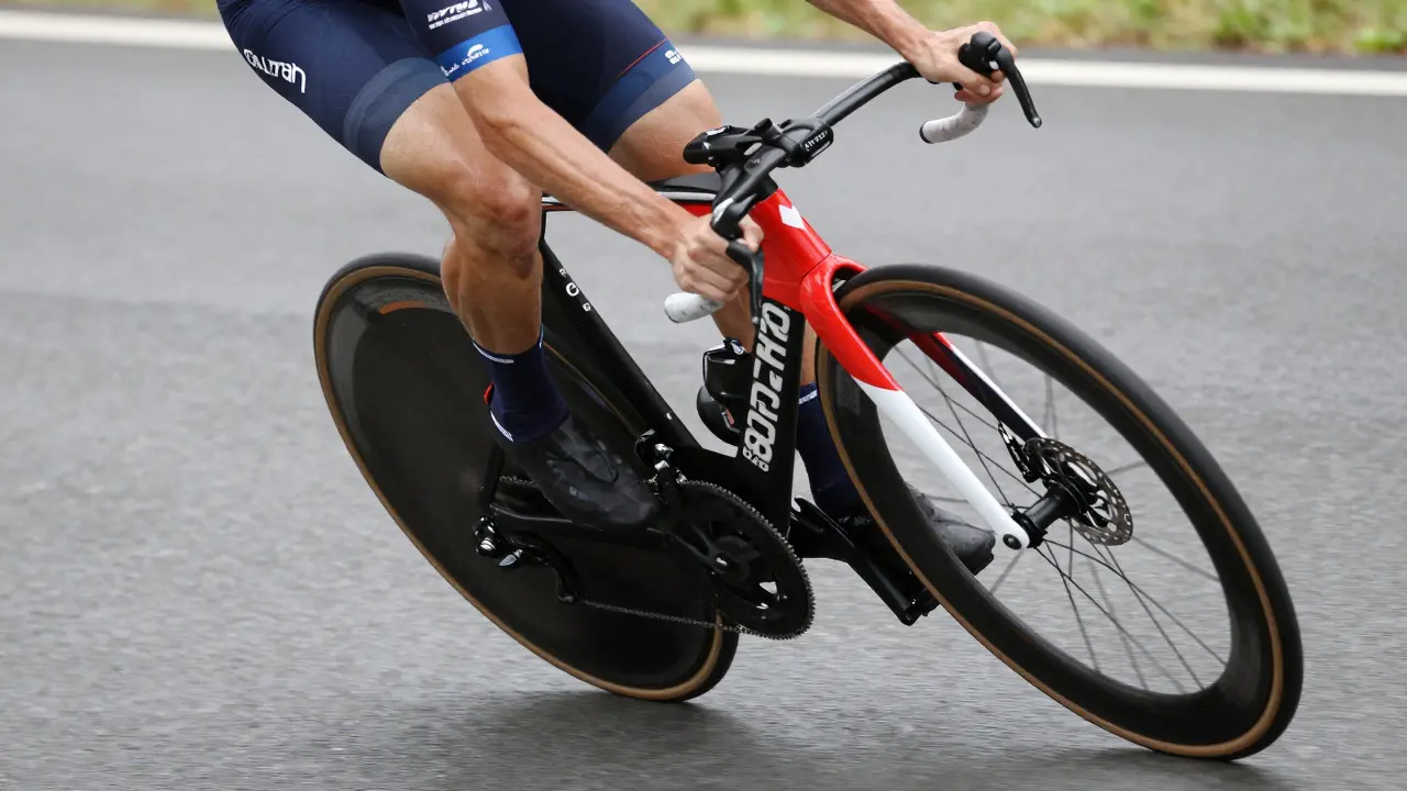 Triatlonista v prudké zatáčce na karbonovém kole s pevnou osou.